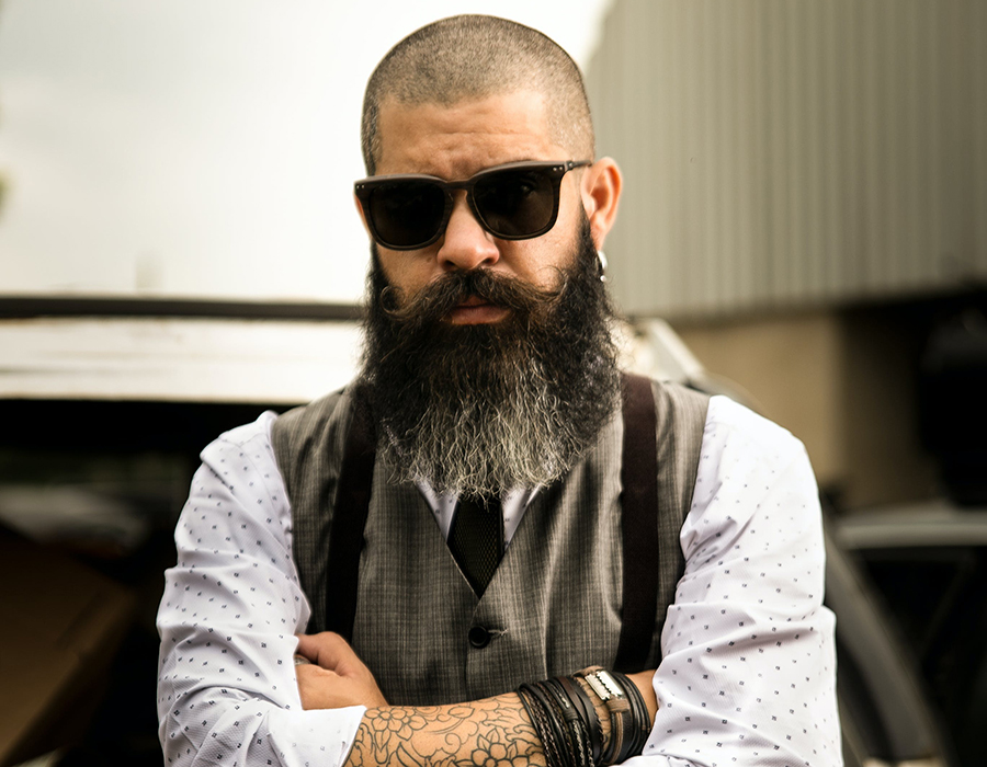 Man with a shaved head and long beard wearing dark sunglasses