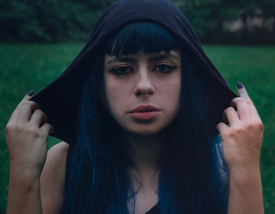Woman with black hair wearing a black hood